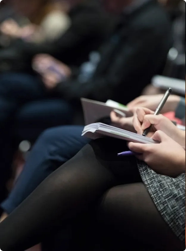 An audience member taking notes during a keynote