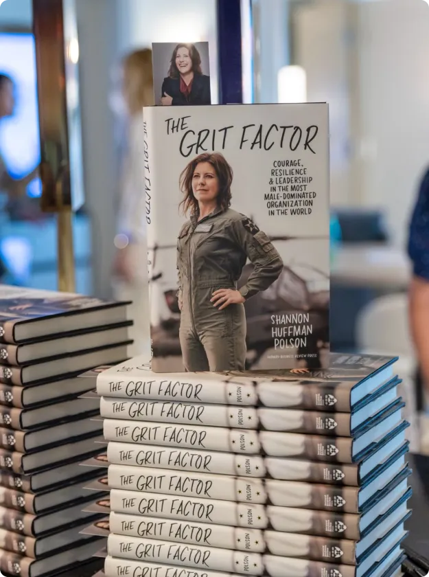 Copies of The Grit Factor stacked on a display table