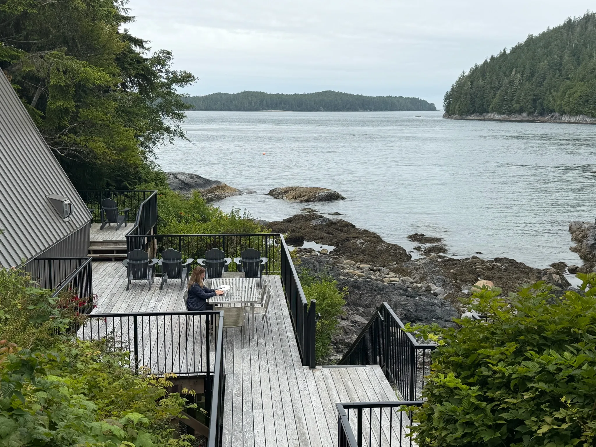 Shannon Huffman Polson writing at a table on a deck above the ocean